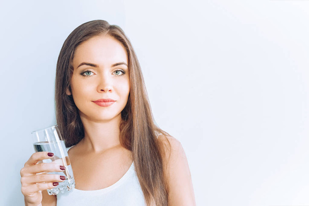 Healthy lifestyle.Young woman drinking from a glass of  fresh water. Healthcare. Drinks. Portrait of happy smiling female model holding transparent glass. Health,Beauty,Diet concept. Healthy eating. - Photo, image