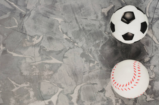 Two new soft rubber soccer and baseball balls on old worn cement - 写真・画像