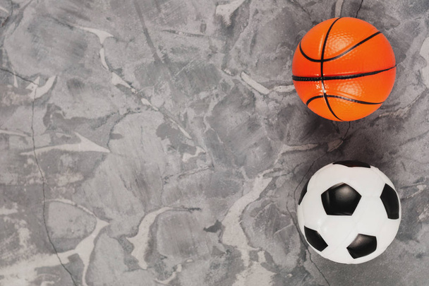 Dvě nová měkká gumová fotbalová a basketbalová koule na starém opotřebované cementárny. Pohled shora - Fotografie, Obrázek