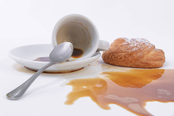 Ρολό χρυσαφένια ζύμη και ένα φλιτζάνι χυμένο καφέ - Φωτογραφία, εικόνα