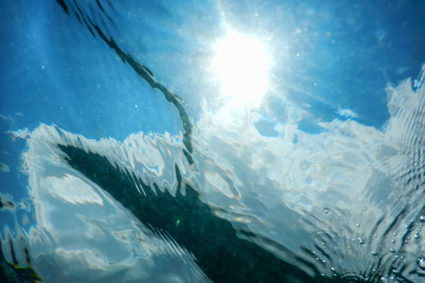 Голубая подводная поверхность и рябь, подводное солнце
 - Фото, изображение