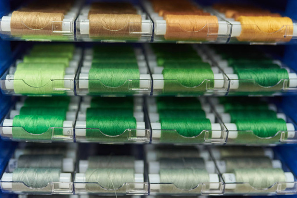 Шнурки смешанных цветов швейная нить на стенде в магазине, выборочная фокусировка, текстура фона
 - Фото, изображение