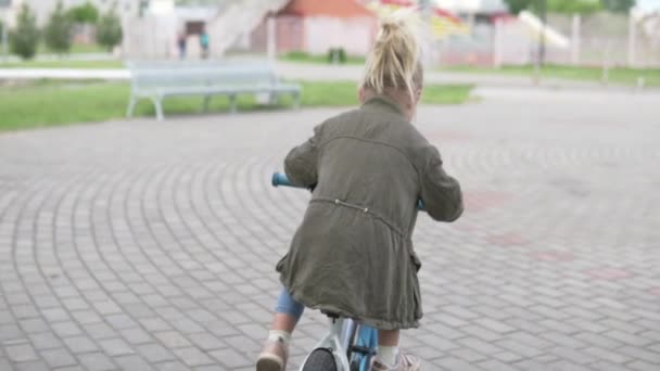 Little girl riding her bike in the park.  - Felvétel, videó