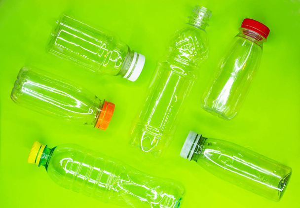 collection of empty used plastic bottles on green background. Recycling waste concept. Top view. - Valokuva, kuva
