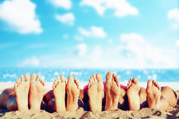 Grupo de amigos divirtiéndose en la playa con sus pies. Concepto de verano
 - Foto, Imagen