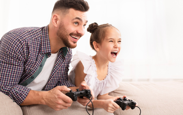 fröhlicher Vater genießt Videospiel mit seiner süßen Tochter - Foto, Bild