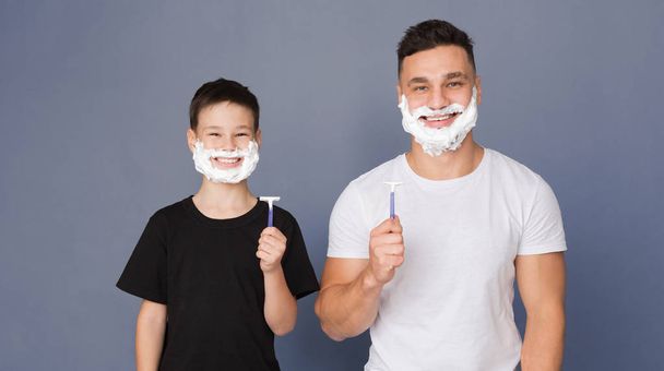 Мужчина и маленький мальчик с пеной для бритья на лицах держат бритвы
 - Фото, изображение