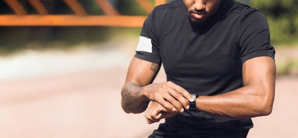 Sportlicher Mann überprüft Herzfrequenz auf Smartwatch - Foto, Bild