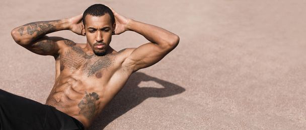 Tetovaný Afro muž cvičení na sportovní půdě - Fotografie, Obrázek