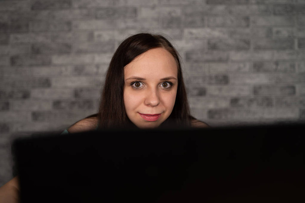 junge Frau mit Laptop vor weißem Backsteinhintergrund, Menschen und Technologie, Lebensstil, Bildung, Geschäftskonzept - Foto, Bild