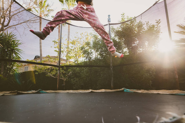 Little girl enjoying her vacation jumping on the trampoline doin - Photo, Image