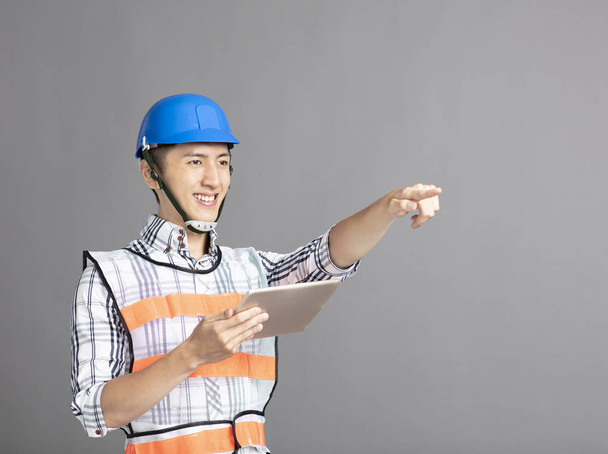 smiling asian young man construction worker - Foto, afbeelding