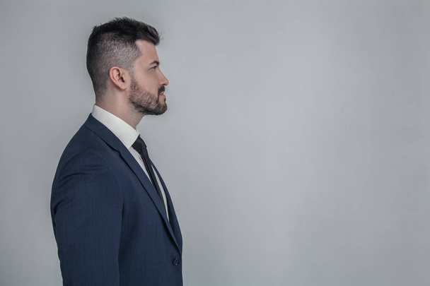 Half-faced profile side view close up portrait of serious focused handsome attractive style stylish modern masculine guy with trendy hairstyle isolated on gray background copy-sapce - Foto, imagen