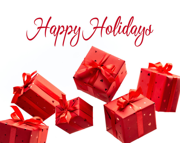 Gift box. Photos in fashionable style. Red gift boxes hang in air on white background. Happy Holidays. - Foto, Imagem