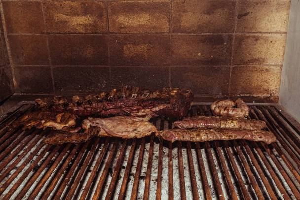 "Parrillada" Argentine barbecue make on live coal (no flame), beef "asado", bread, "Chorizo" - Photo, Image