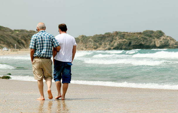 adult son and father walking together on the beach - Foto, Bild