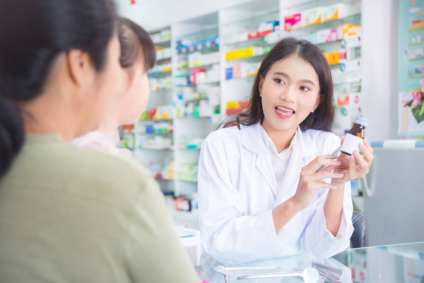 Pharmacist explaining the pills to patient in drug store - Zdjęcie, obraz