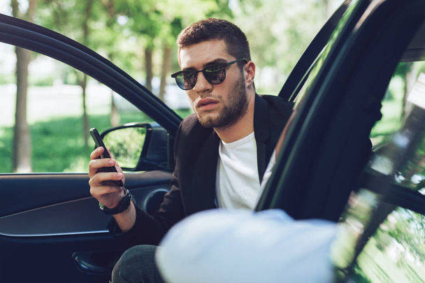 Young attractive man using mobile phone in his car  - Valokuva, kuva