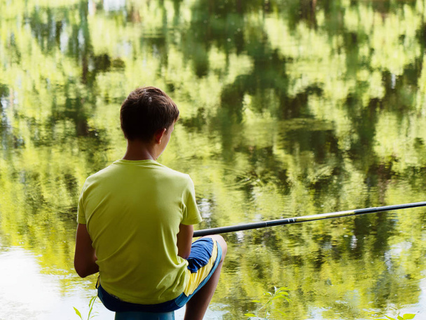 teen child catches a fishing rod on the pond. - Photo, Image
