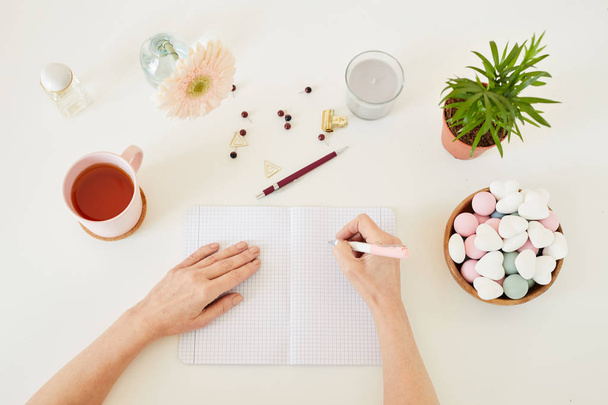 Mãos de designer feminino com caneta sobre página em branco de livro de recordações chegando com ideias criativas antes de escrevê-los para baixo
 - Foto, Imagem