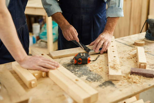 Close-up van timmerlieden werkstation met senior man meten van hout, kopieer ruimte - Foto, afbeelding