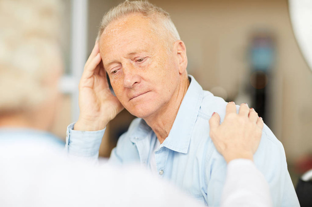 Muotokuva turhautunut vanhempi mies kuuntelee lääkärin kuulemisen aikana klinikalla, kopioi tilaa
 - Valokuva, kuva