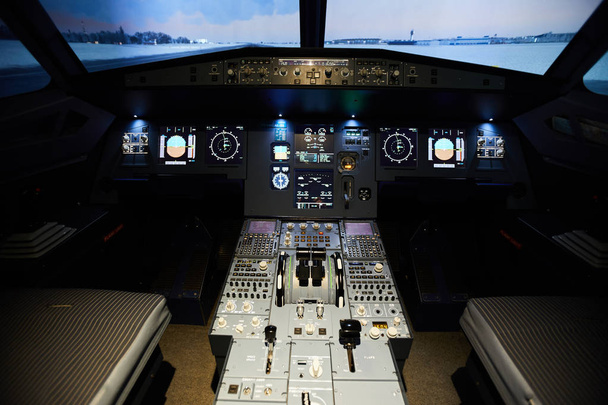 Interior moderno do cockpit vazio com painel de bordo de aeronaves cheio de vários botões, alças e dispositivos de monitoramento
 - Foto, Imagem