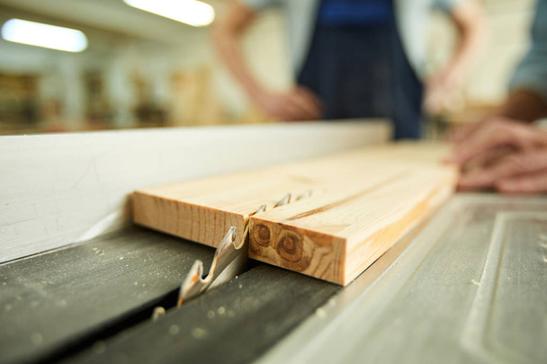 Primer plano de carpintero irreconocible cortando madera usando sierra de disco en taller de carpintería, espacio de copia
 - Foto, imagen