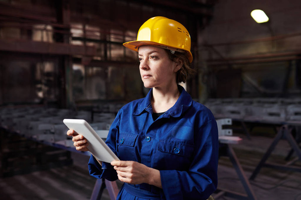 Retrato de la cintura hacia arriba de la mujer adulta que trabaja en fábrica y que usa la tableta, espacio de copia
 - Foto, imagen