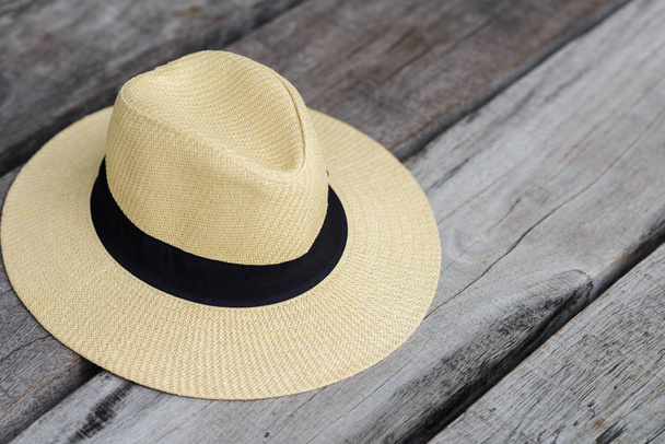 соломенная пляжная шляпа с черной лентой на деревянном сиденье с бесплатным пространством, летняя концепция путешествия
 - Фото, изображение