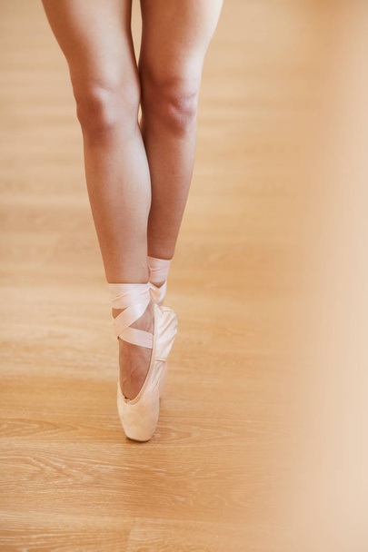 Close-up of unrecognizable woman in pointe shoes standing on tiptoes while performing ballet at rehearsal - Photo, Image