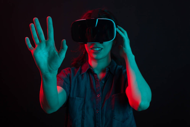 Joyeux jeune femme surprise en regardant un film en utilisant un casque de réalité virtuelle
 - Photo, image