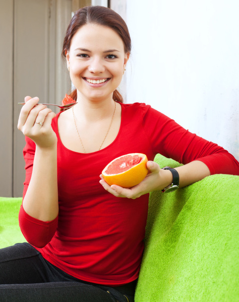 молодая женщина ест грейпфрут ложкой
 - Фото, изображение