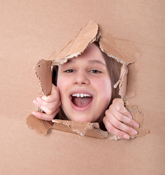 kid portrait in torn paper hole - Zdjęcie, obraz