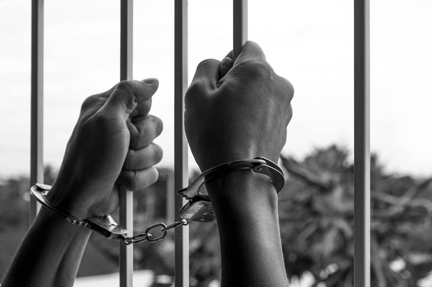 Kezek Handcuffed a férfi fogoly börtönben Holding Steel Lat - Fotó, kép