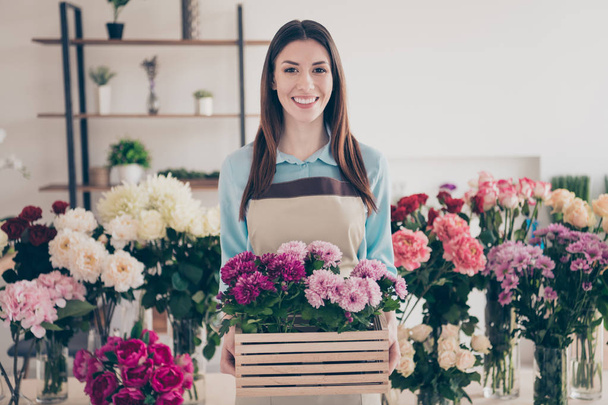 Portrait of cute charming lovely vendor hold hand bouquet bunch offer option product feel glad ads wear blue shirt trendy stylish blue beautiful hairstyle long orangery - 写真・画像