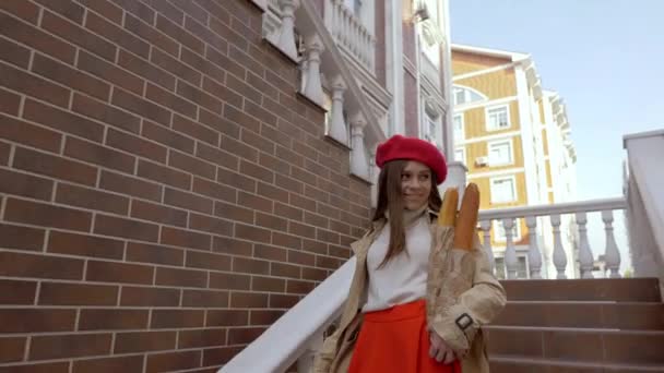 dívka přichází v červeném baretu po schodech s bagety v dlaních - Záběry, video