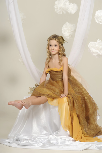 Portrait of a beautiful girl in a gold dress - Foto, Bild