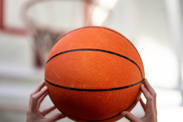 手にバスケットボールのためのボール。スポーツ。バスケットボールコートとリング。スポーツゲーム。健康的なライフスタイル. - 写真・画像