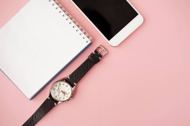 Stationery, white smartphone, pen, wallet, watch, calendar, notebook. Pink background. - Foto, immagini