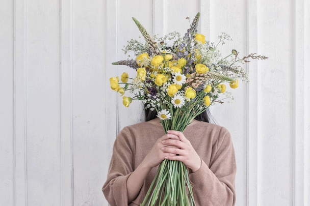 femme tenant bouquet de fleurs jaunes sauvages
 - Photo, image