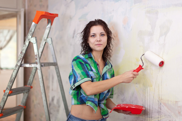 woman paints wall with roller - Foto, Imagem
