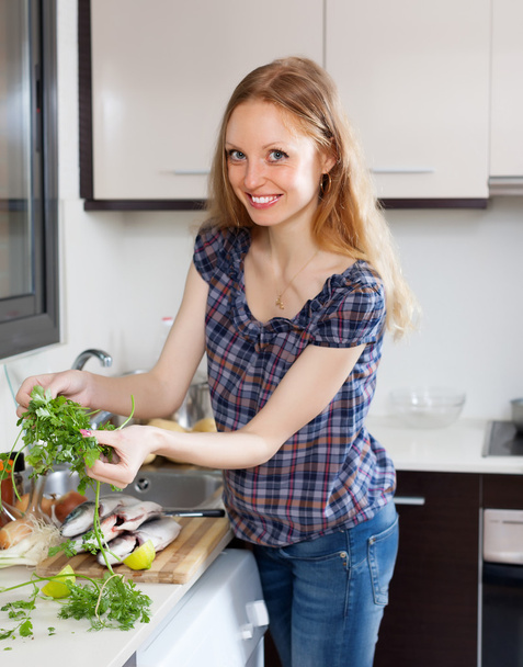 Smiling woman with raw fish and parsley - Foto, Imagen