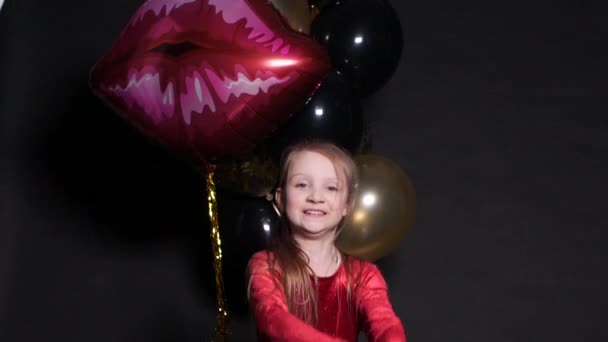 Mooie gelukkige kleine meid springen met confetti en lucht ballonnen in de achtergrond. - Video