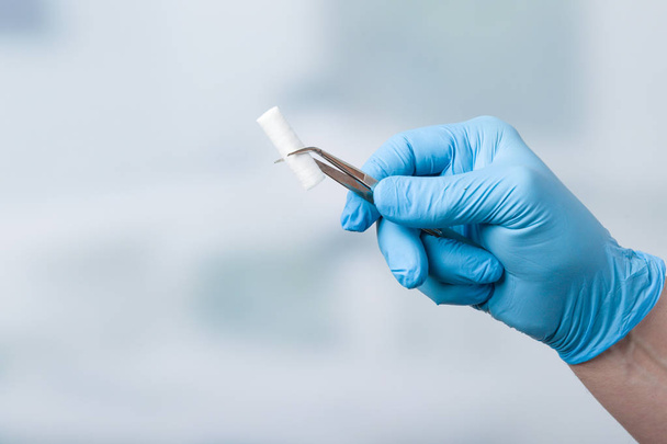Рука стоматолога з бавовняним рулоном
 - Фото, зображення