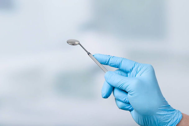 Tandarts hand met tandheelkundige spiegel - Foto, afbeelding
