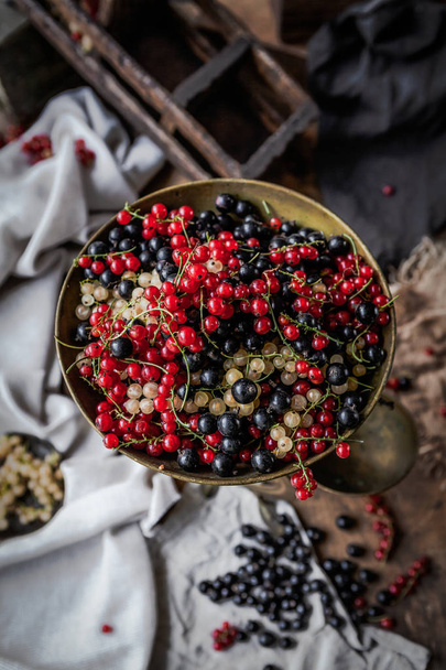 Close view of fresh currant berries in copper bowl on blurry background  - Zdjęcie, obraz