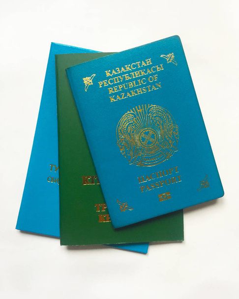 Documenti di un cittadino della Repubblica del Kazakistan. Passaporto, certificato di nascita e libretto di lavoro. Primo piano su sfondo bianco
. - Foto, immagini