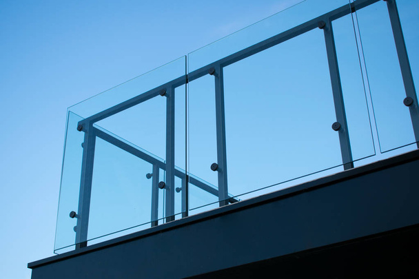 Tempered glass balcony railing. Sky blue background. - Photo, Image