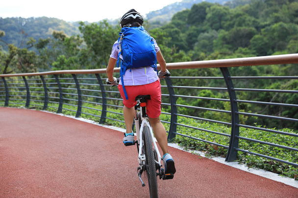 Radfahrerin mit Mountainbike auf Waldweg unterwegs - Foto, Bild